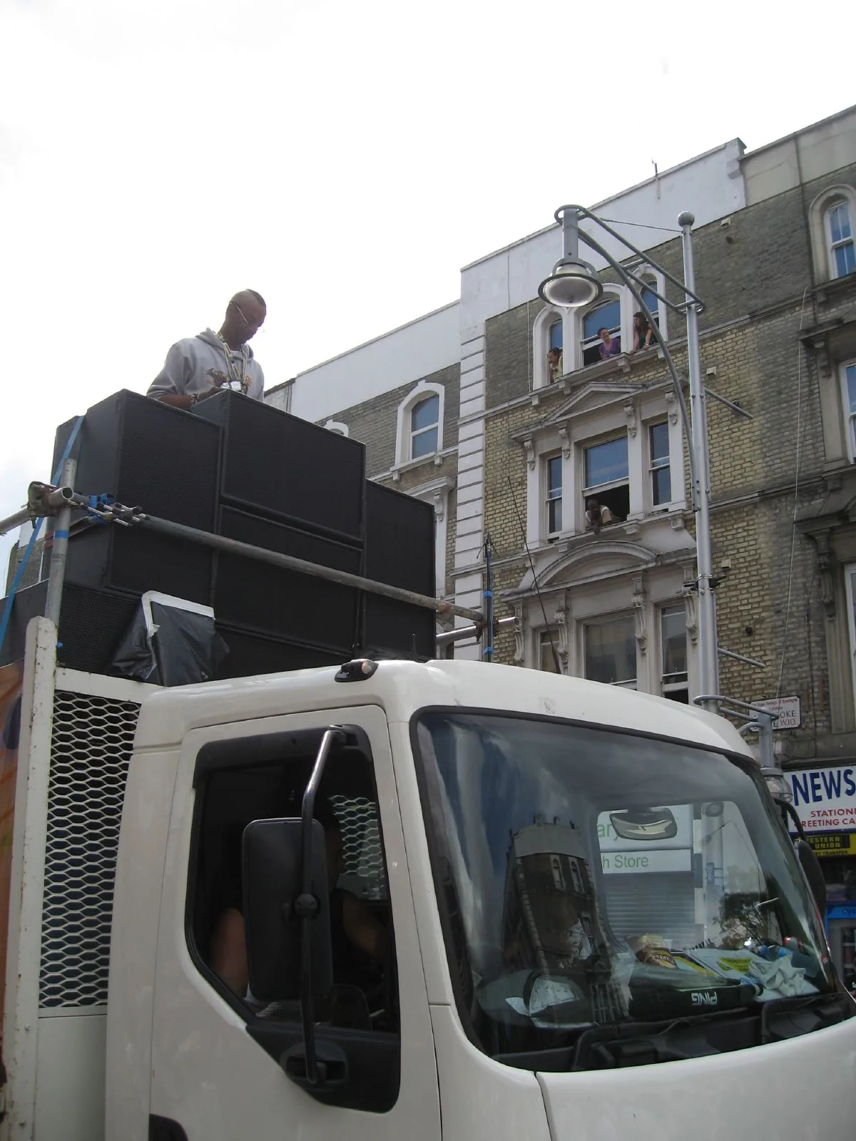 A Black selector works above a truck-mounted stack while residents watch from open windows