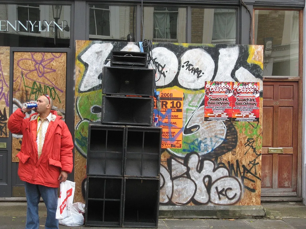 A tall black sound-system stack built against a graffiti-covered wall at Notting Hill Carnival