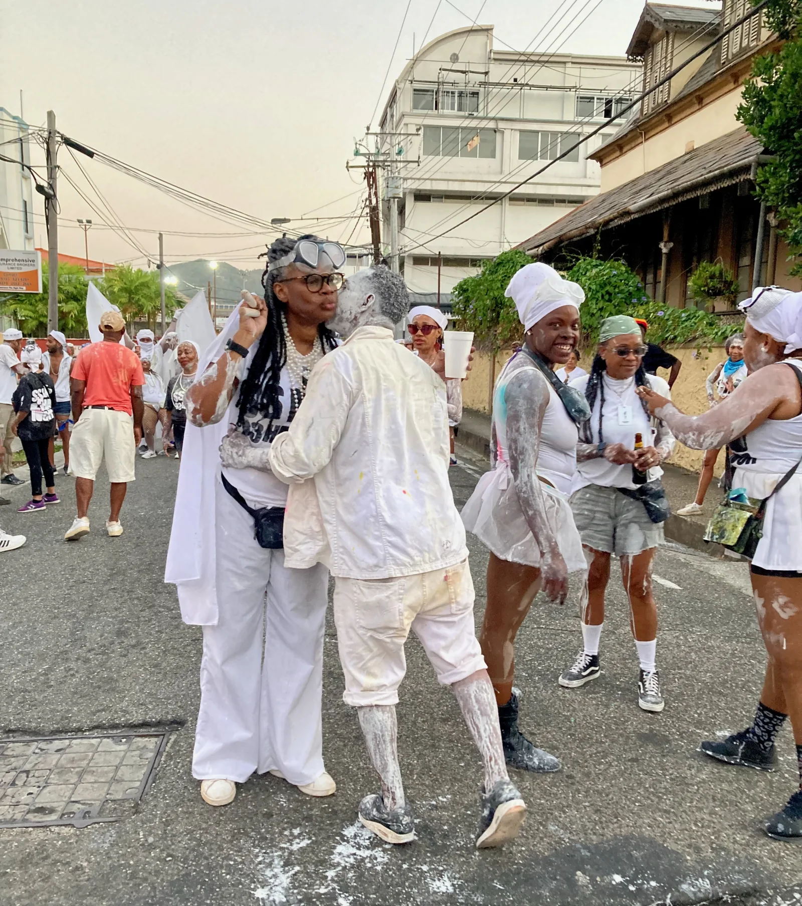 J’ouvert masqueraders in white, dusted with powder, greeting each other in Port of Spain at dawn