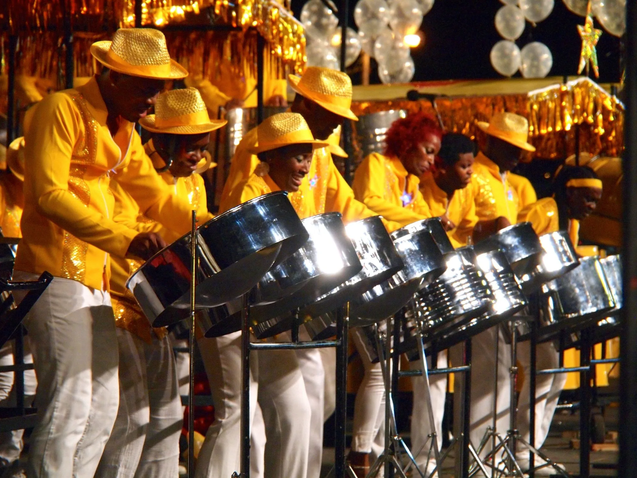 A Trinidad and Tobago steel orchestra in matching yellow costumes performs at Carnival